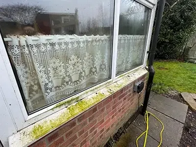 UPVC window frame and sill stained green before cleaning