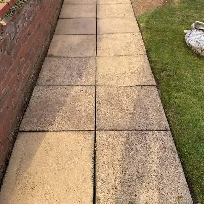 Patio slabs beside a brick wall after cleaning