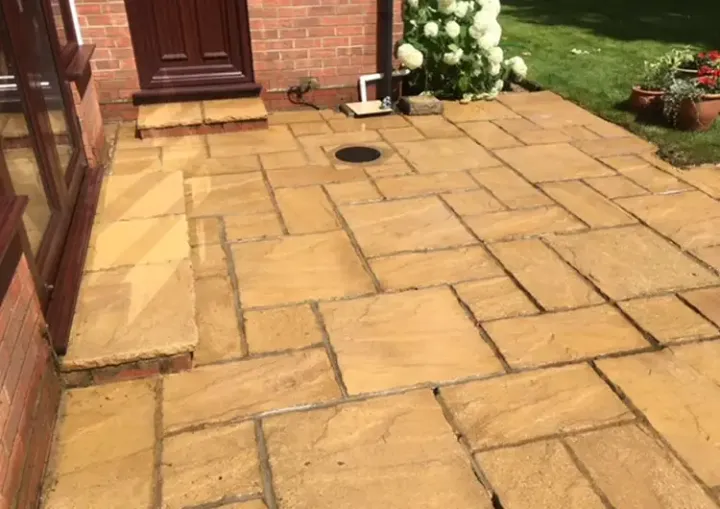 Clean sandstone patio outside a red brick house in Norfolk