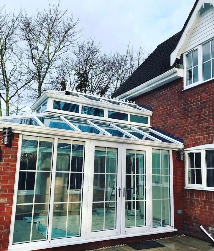 Clean conservatory roof on a red-brick house