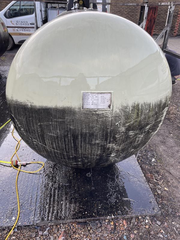 Large stone sphere water feature, top half cleaned to show the difference